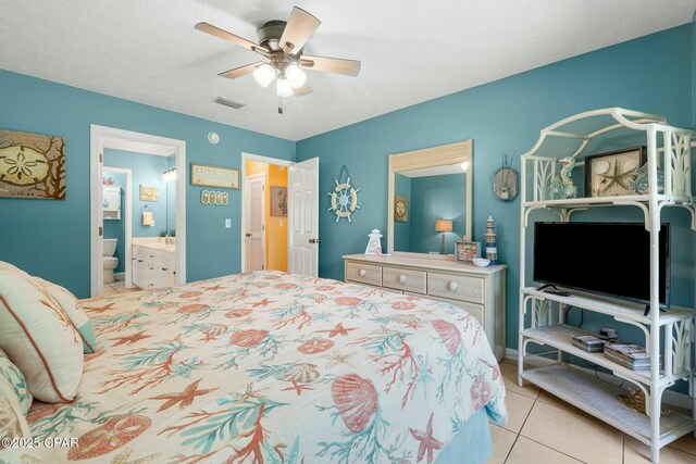 bedroom with a textured ceiling, tile patterned flooring, visible vents, a ceiling fan, and ensuite bath