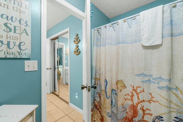 full bathroom featuring a textured ceiling, a shower with shower curtain, and tile patterned flooring