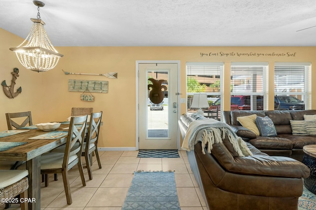 living area featuring an inviting chandelier, baseboards, a textured ceiling, and light tile patterned flooring