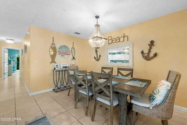 dining space with a chandelier, light tile patterned flooring, and baseboards