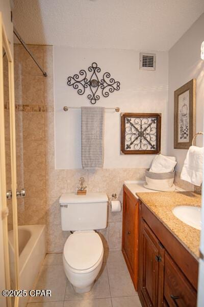 8817 Thomas Dr Unit A618, Panama City Beach, FL 32408 - bathroom with vanity, toilet, tile patterned flooring,  shower combination, and tile walls