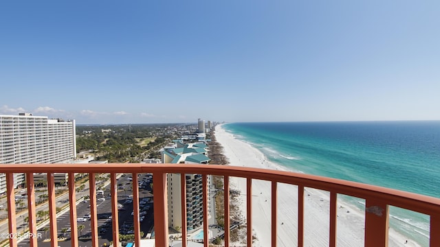 balcony with a water view and a view of the beach