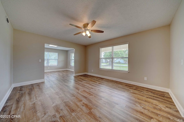 spare room featuring ceiling fan, a textured ceiling, baseboards, and wood finished floors