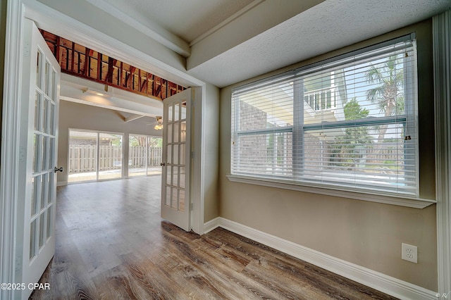 spare room with baseboards, wood finished floors, and french doors