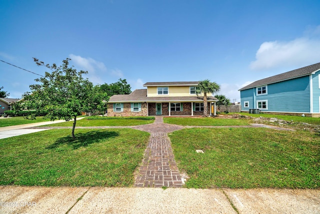 view of front of property with a porch, brick siding, driveway, and a front lawn