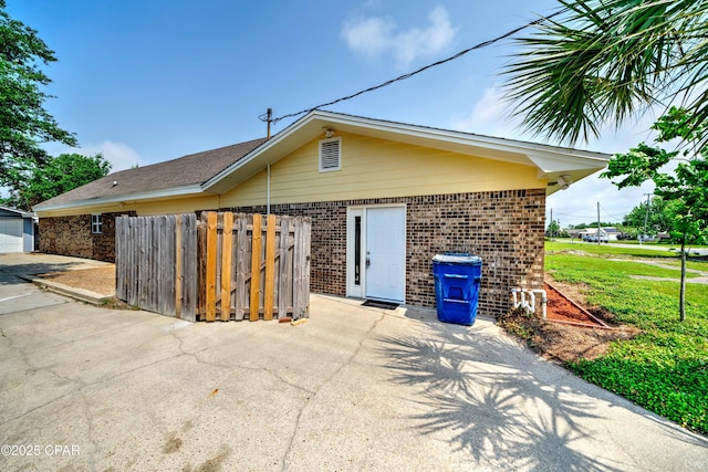 exterior space with brick siding and fence