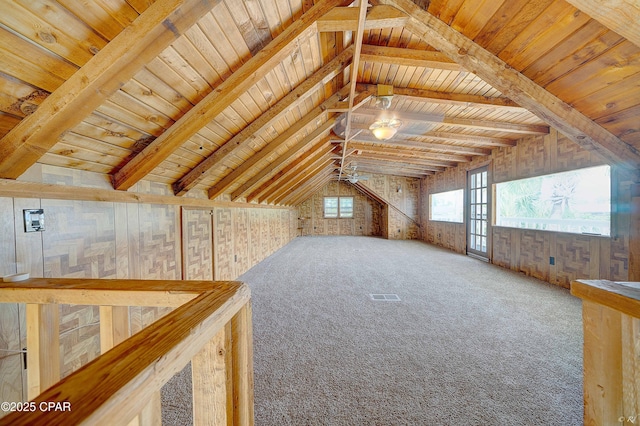 additional living space featuring vaulted ceiling with beams, wood walls, carpet flooring, wood ceiling, and visible vents