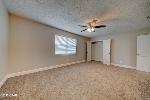 unfurnished bedroom featuring baseboards, ceiling fan, a textured ceiling, carpet flooring, and a closet