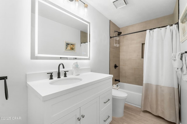 full bathroom featuring toilet, wood-type flooring, vanity, and shower / tub combo