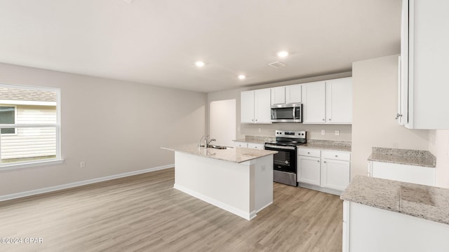 kitchen featuring a sink, appliances with stainless steel finishes, light wood-style flooring, and white cabinetry