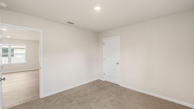 carpeted empty room with visible vents, recessed lighting, and baseboards