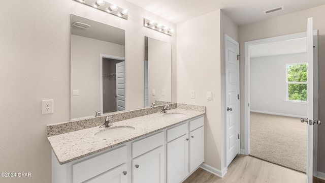 full bathroom with a sink, baseboards, and double vanity