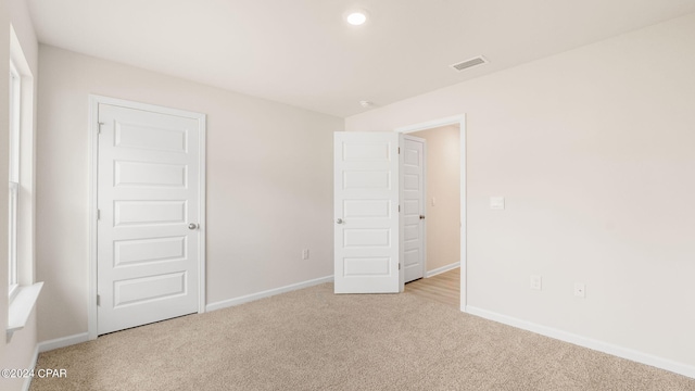 unfurnished bedroom featuring visible vents, baseboards, and carpet floors