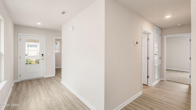 hall featuring light wood finished floors, visible vents, recessed lighting, and baseboards