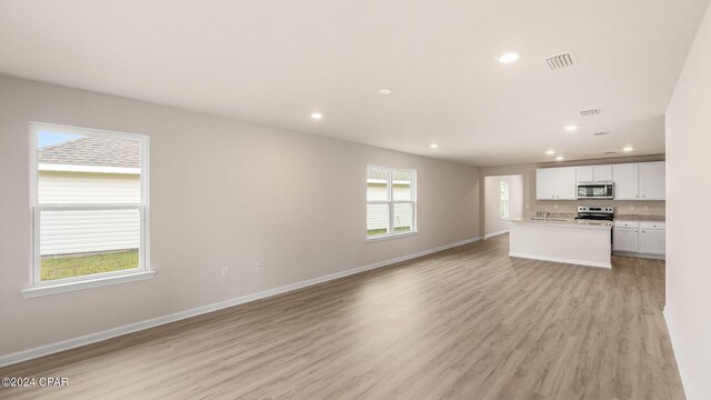 unfurnished living room featuring recessed lighting, light wood-type flooring, baseboards, and visible vents