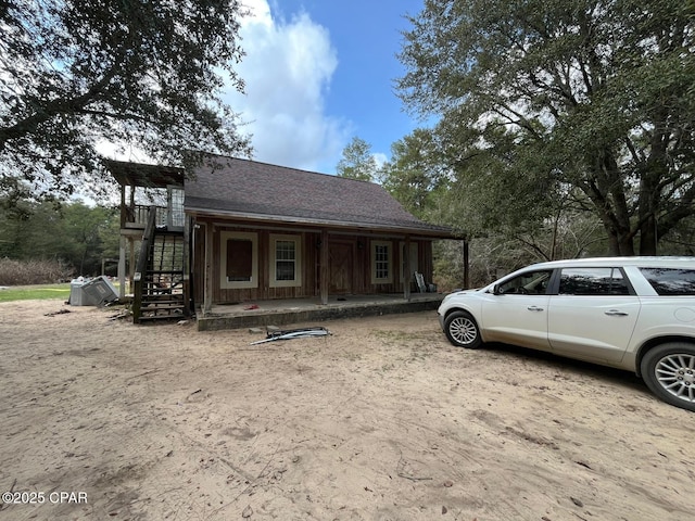 view of front of property featuring a shingled roof and stairs