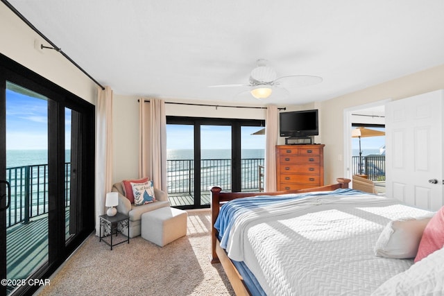 bedroom with a water view, access to exterior, and carpet floors