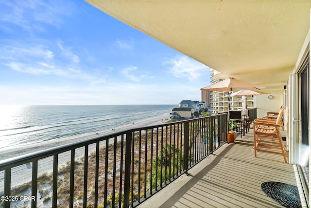 balcony featuring a water view and a beach view