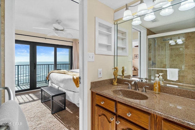 ensuite bathroom featuring built in features, connected bathroom, a ceiling fan, vanity, and a shower stall