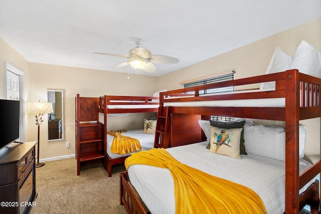 carpeted bedroom with ceiling fan and baseboards