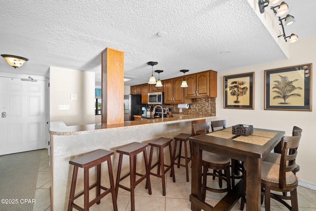 dining space featuring light tile patterned flooring and a textured ceiling