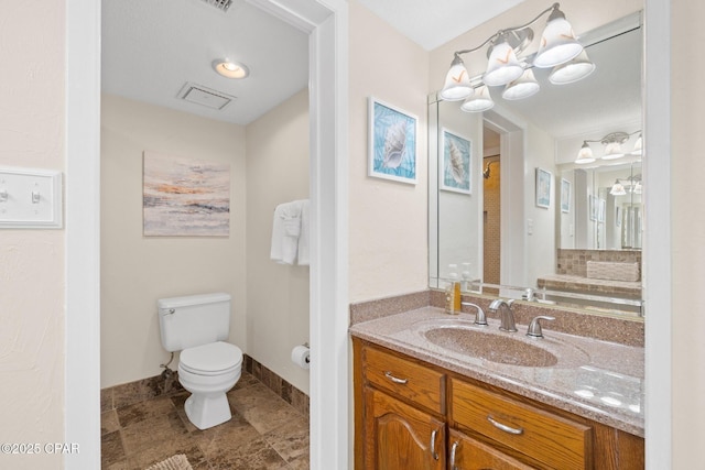 bathroom featuring toilet, baseboards, and vanity