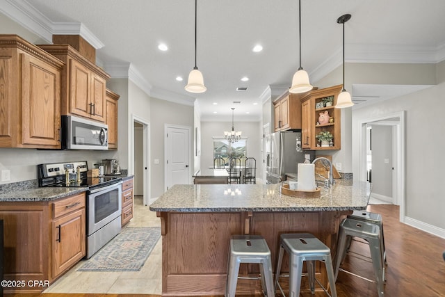 kitchen featuring stainless steel appliances, light stone countertops, a kitchen bar, crown molding, and pendant lighting