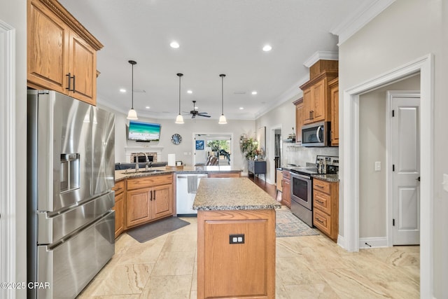 kitchen featuring appliances with stainless steel finishes, hanging light fixtures, a center island, sink, and kitchen peninsula