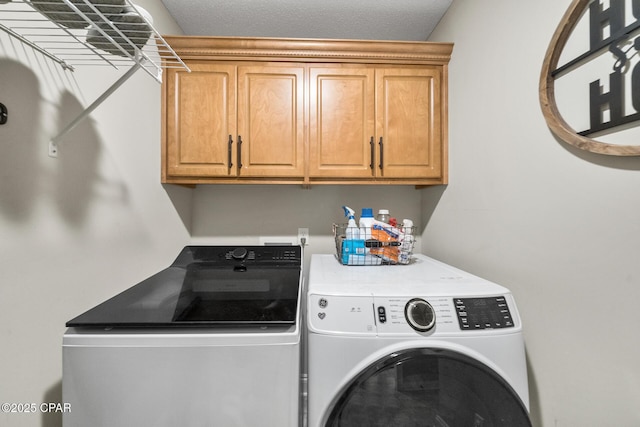 laundry room featuring cabinets and washing machine and clothes dryer