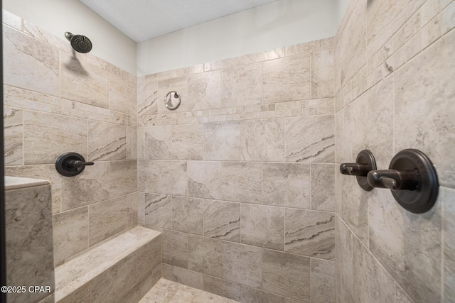 bathroom featuring a tile shower and a textured ceiling