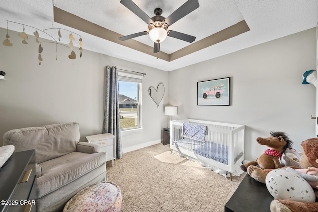 bedroom with a tray ceiling, ceiling fan, and carpet