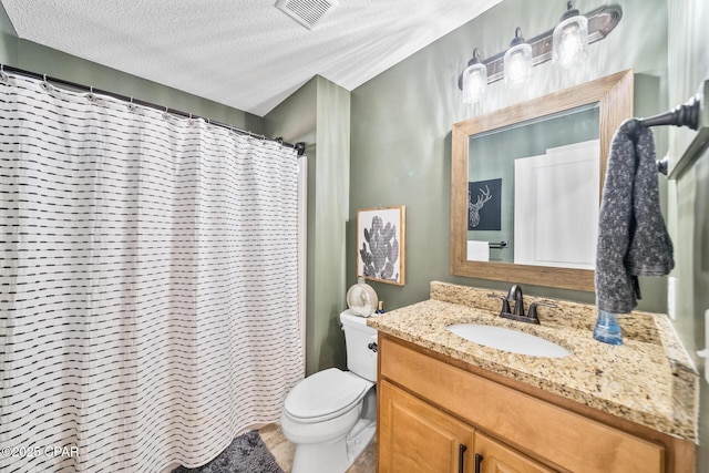 bathroom featuring toilet, a textured ceiling, curtained shower, and vanity