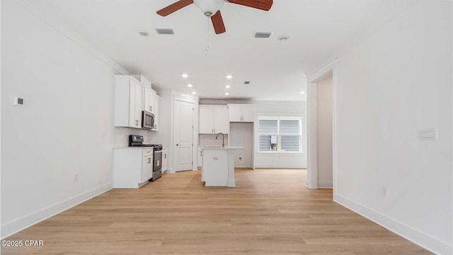 kitchen featuring visible vents, light wood-style flooring, a sink, stainless steel appliances, and white cabinetry