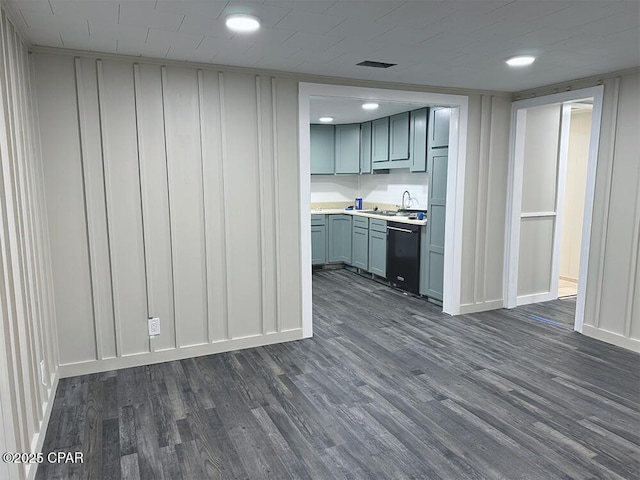 kitchen with dark wood-type flooring, black dishwasher, gray cabinetry, and sink