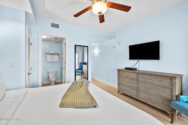 bedroom with ceiling fan, connected bathroom, visible vents, baseboards, and light wood finished floors