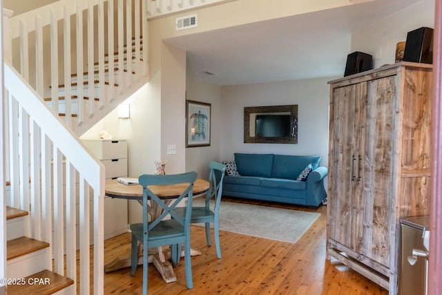 dining room featuring stairs, visible vents, and light wood-style floors