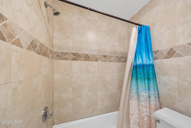 bathroom featuring shower / tub combo and toilet