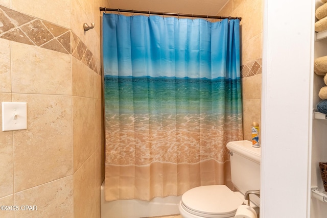 bathroom with toilet, tile walls, and shower / tub combo with curtain