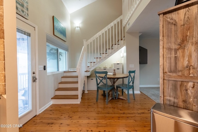 entrance foyer with stairway, baseboards, and wood finished floors