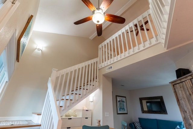 staircase featuring visible vents, beam ceiling, a towering ceiling, and a ceiling fan