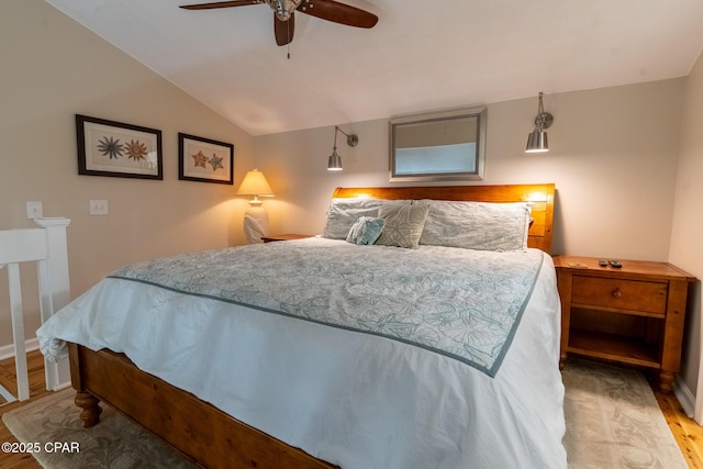 bedroom with lofted ceiling, wood finished floors, a ceiling fan, and baseboards