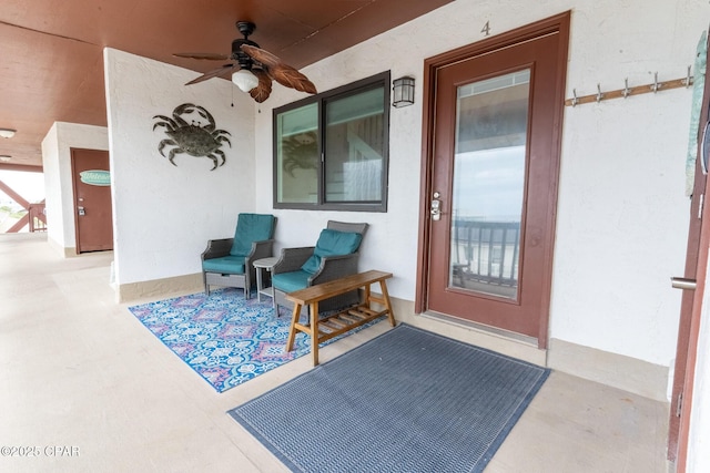 doorway to property with a ceiling fan and stucco siding