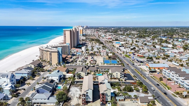 drone / aerial view featuring a water view, a view of city, and a beach view