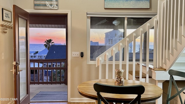 interior space featuring a water view, baseboards, and stairs