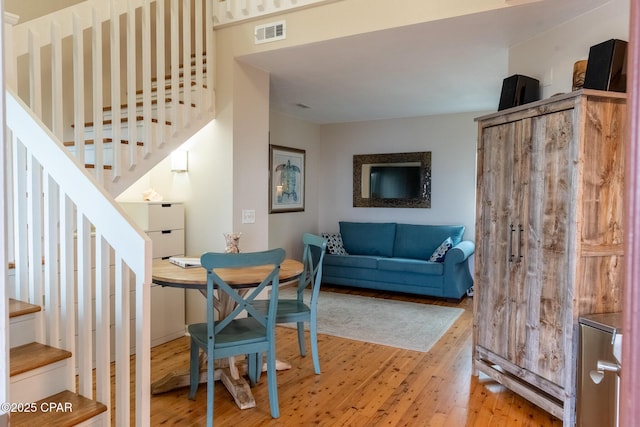 dining space featuring stairs, visible vents, and light wood-style floors