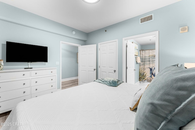 9860 S Thomas Dr Unit 1919, Panama City, FL 32408 - bedroom with visible vents, baseboards, and wood finished floors