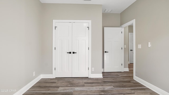 unfurnished bedroom featuring a closet and dark hardwood / wood-style floors