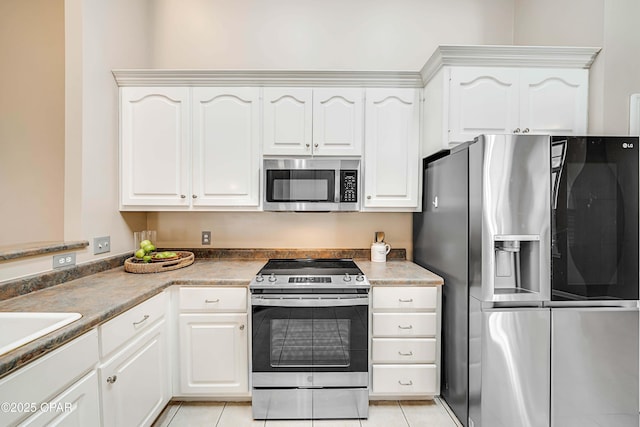 kitchen with light tile patterned floors, white cabinetry, and stainless steel appliances