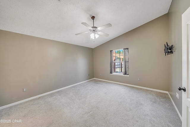 spare room featuring light colored carpet, a ceiling fan, vaulted ceiling, a textured ceiling, and baseboards