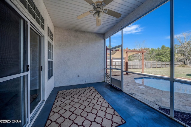 unfurnished sunroom featuring ceiling fan